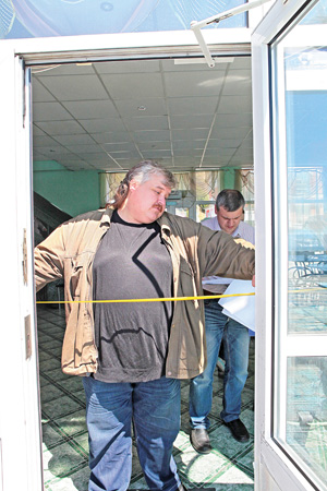 Заместитель председателя Забайкальской краевой организации ВОИ Сергей Петров замеряет проем двери 