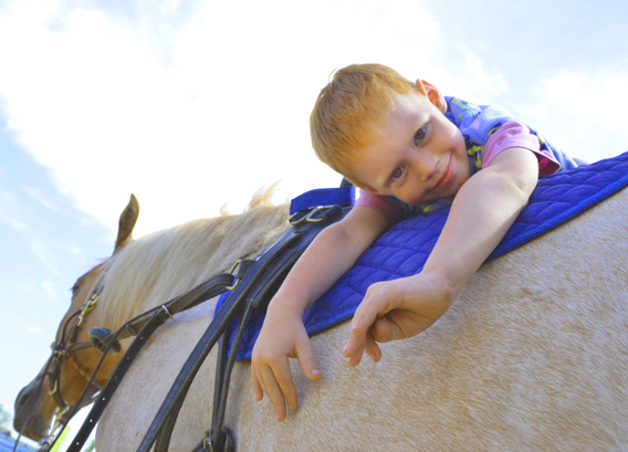 Четырехлетний Илья  на спине коня по кличке Табат. Фото Анны  АНДРЕЕВОЙ