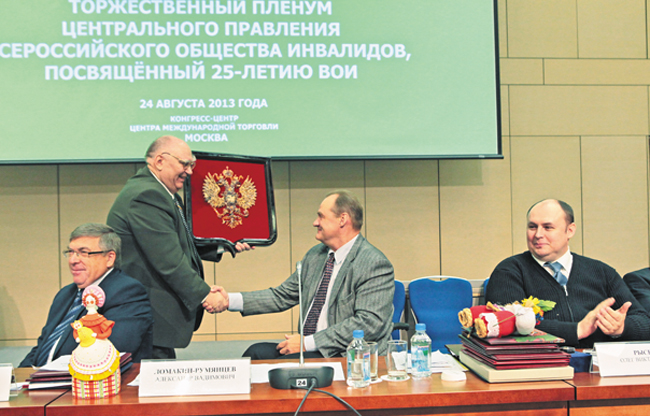 И.Я. Разиньков вручает председателю ВОИ А.В. Ломакину-Румянцеву герб России, выполненный из янтаря