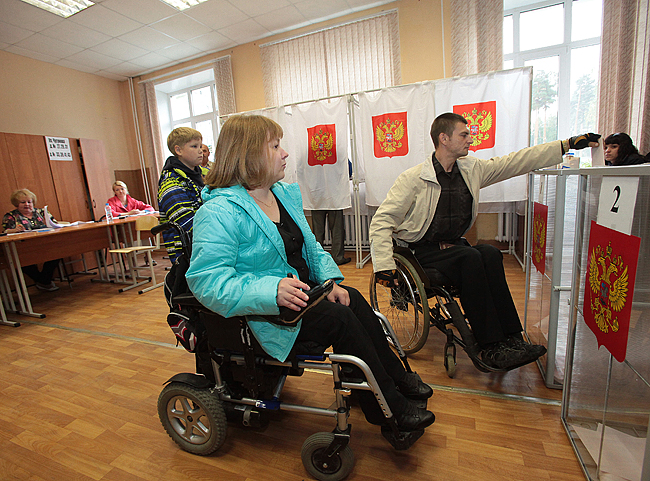 ители города Раменское Московской области  Олеся Фролова и Алексей Прусов голосуют на избирательном участке.